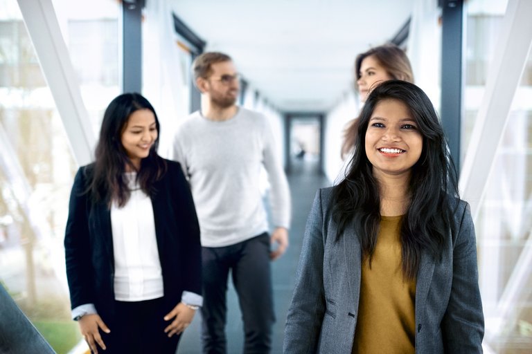 A group of young people walk down a corridor