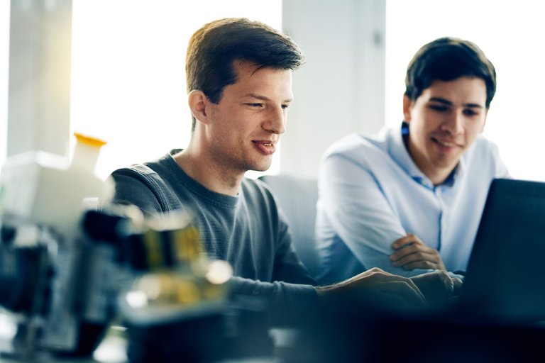 Two men looking at a laptop together