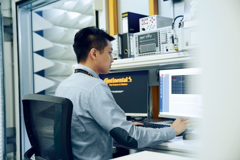 A man is sitting in front of two PC screens